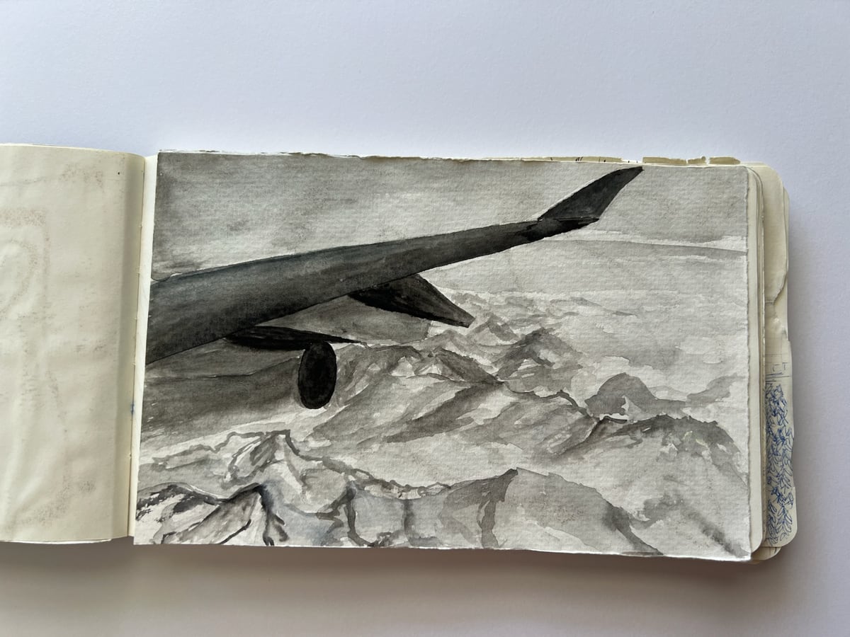Skizze eines Flugzeugflügels über einer Gebirgslandschaft